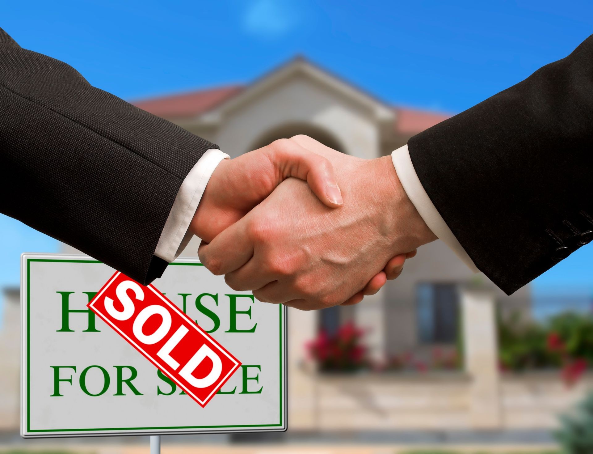 Home For Sale Real Estate Sign in Front of Beautiful New House Sold. Blurred background. Handshake business deal. Communication commerce real estate. Corporate concept